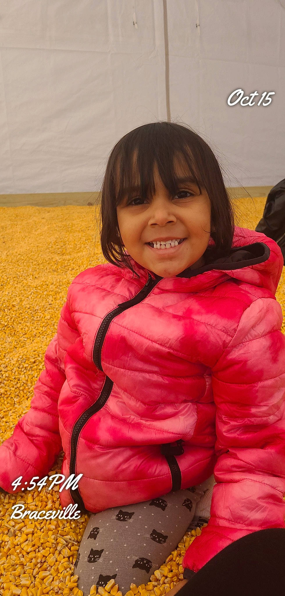 Penelope Ann is registered to the contest to win money with this photo: bangs, black_hair, brown_hair, child, facial_expression, fun, happy, human_leg, jacket, joy, leisure, long_hair, magenta, person, pink, sitting, skin, sleeve, smile, thigh