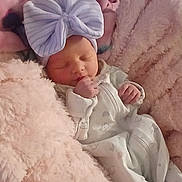 Amirah is registered to the contest to win money with this photo: baby, newborn, blanket, bow, sleeping, infant, soft, pink, cozy, clothing, person, indoor, cute, child, fabric, headwear, resting, wrapped, mickey_mouse, floor