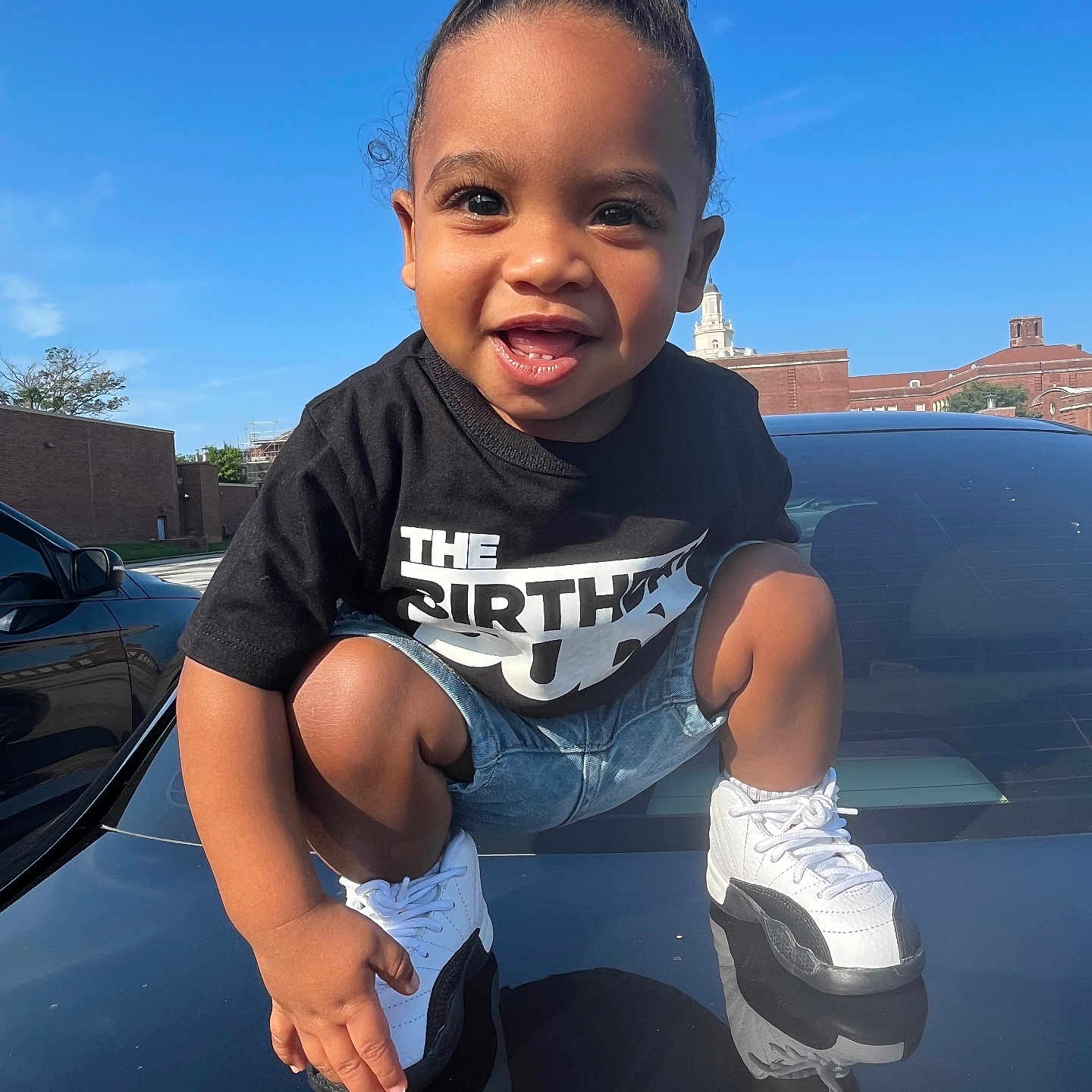 Tyson joined the competition — help win amazing prizes! baby, babylaughing, blackhair, car, clothing, face, footwear, hair, happy, head, person, photography, portrait, shoe, shorts, sitting, sleeve, sneaker, transportation, vehicle