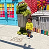 Thomas joined the competition — help win amazing prizes! brick_wall, building, character, child, colorful, costume, curly_hair, daylight, flower_decoration, outdoor, person, puppet, shorts, sidewalk, smile, sneakers, toddler, trash_can, window, yellow_shirt