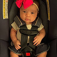 Alyssa joined the competition — help win amazing prizes! baby, infant, car_seat, bow, headband, straps, clothing, barefoot, child, seatbelt, cute, young, portrait, indoors, sitting, person, small_hands, legs, face, safety