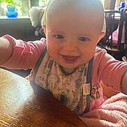 Dallas Morgan is registered to the contest to win money with this photo: baby, bib, child, cozy, cute, face, furniture, greenery, happy, indoor, infant, natural_light, person, pink_clothing, playful, portrait, smile, table, window, wood