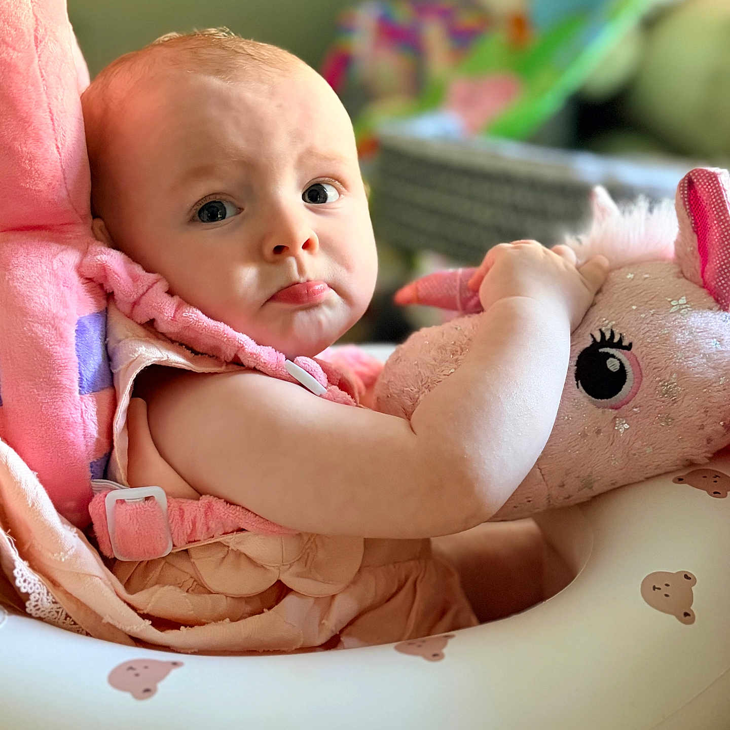 Dallas Morgan is registered to the contest to win money with this photo: baby, baby_seat, bear_pattern, child, closeup, clothing, comfort, cute, expression, home, indoor, infant, person, pink, plush_toy, portrait, pouty, seat, soft_toys, unicorn