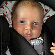 Chiara participe au concours pour gagner de l'argent avec cette photo : baby, infant, face, blue_eyes, car_seat, heart_pattern, clothing, child, portrait, cute, young, skin, expression, soft_light, closeup, head, hand, seat_belt, comfort, young_child