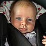 baby, infant, face, blue_eyes, car_seat, heart_pattern, clothing, child, portrait, cute, young, skin, expression, soft_light, closeup, head, hand, seat_belt, comfort, young_child