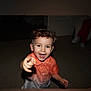 child, boy, curly_hair, smiling, pointing, indoor, shirt, happy, portrait, person, toddler, face, cute, light, flash, young, fun, expression, casual, playful