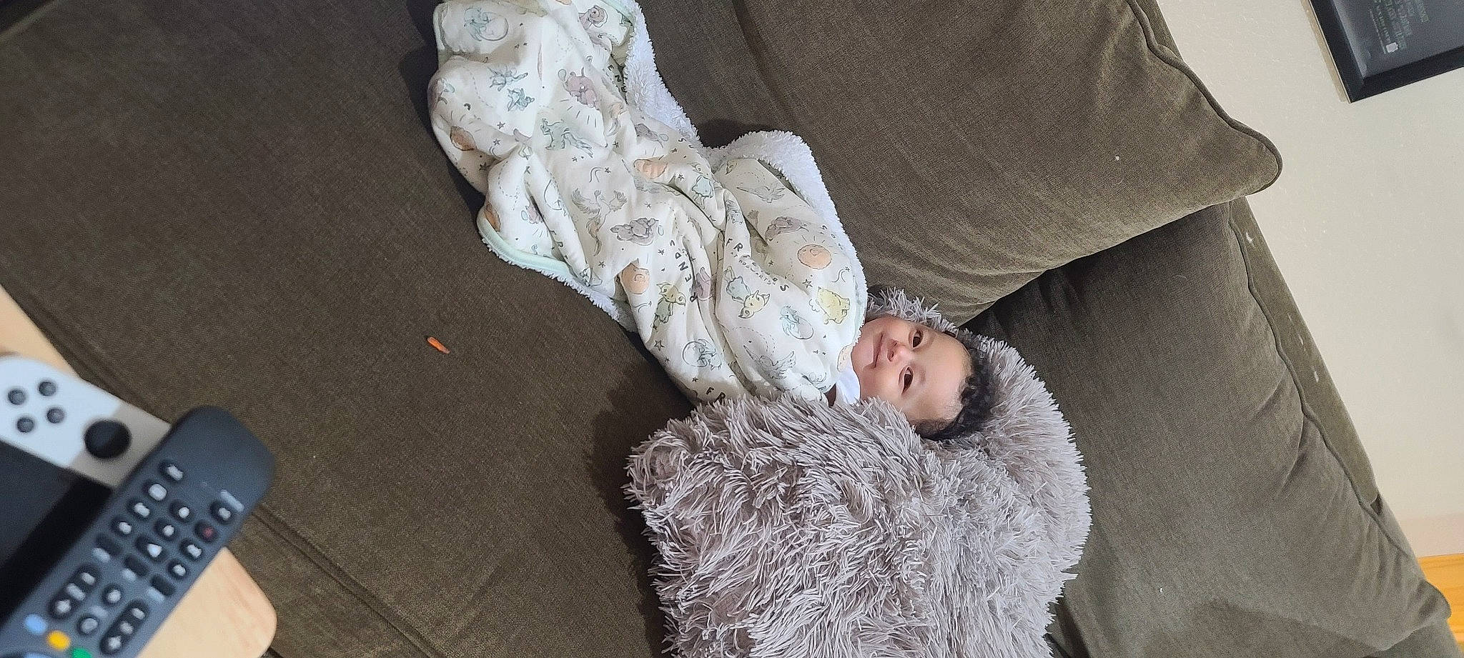 Legacy is registered to the contest to win money with this photo: bedding, child, comfort, flooring, foot, fur, fur_clothing, gesture, human_leg, linens, military_camouflage, nap, pattern, person, room, sitting, sleep, sleeve, toddler, wood