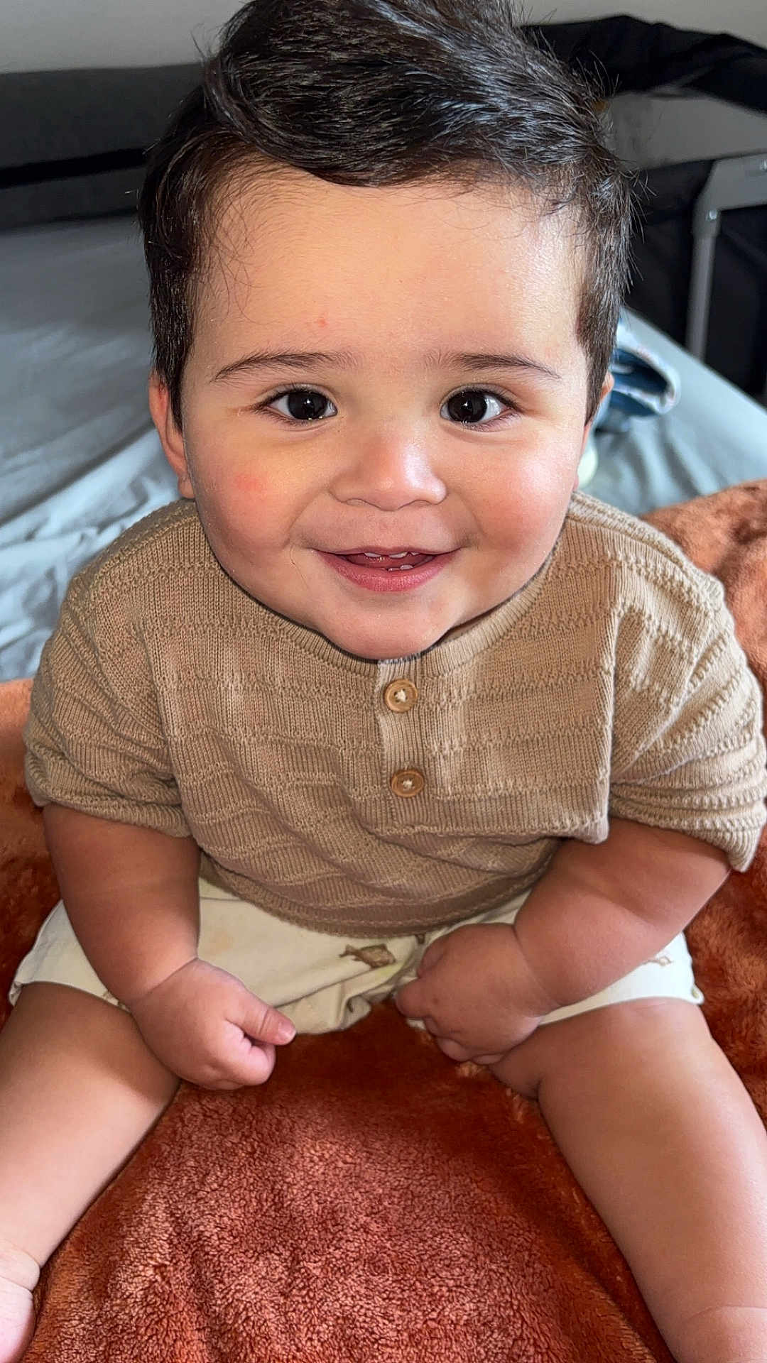 Arsenio joined the competition — help win amazing prizes! baby, child, smiling, sitting, knit_sweater, shorts, blanket, indoors, cute, happy, face, arms, legs, skin, hair, buttoned_shirt, infant, portrait, warm_colors, cozy