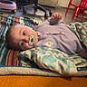 River joined the competition — help win amazing prizes! baby, pacifier, blanket, floor, chair, office_chair, door, indoor, child, clothing, person, carpet, colorful, pattern, furniture, curious, lying_down, cozy, home, room
