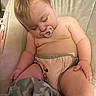 River is registered to the contest to win money with this photo: baby, child, sleeping, pacifier, diaper, toddler, blanket, giraffe_pattern, cushion, seat, indoor, cute, peaceful, skin, hair, hand, leg, rest, nap, comfort