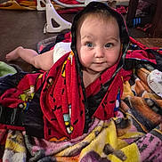 River joined the competition — help win amazing prizes! baby, blanket, child, indoor, dog, floor, furniture, carpet, face, blue_eyes, curious, couch, wood_floor, colorful, hooded_blanket, pet, toddler, cute, lying_down, comfort