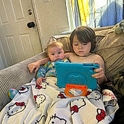 Jaxson joined the competition — help win amazing prizes! child, baby, tablet, couch, blanket, hello_kitty, indoor, curtains, door, furniture, technology, screen, sitting, siblings, family, cozy, focused, casual, relaxed, play