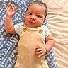 Kyson is registered to the contest to win money with this photo: baby, blanket, button, child, clothing, curious, cute, expression, face, hair, hand_raised, indoors, infant, lying_down, overalls, palm, pocket, skin, soft_texture, striped_shirt