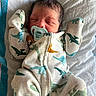 baby, bed, blanket, child, clothing, cozy, cute, dinosaur_pattern, face, head, indoors, infant, lying_down, newborn, onesie, pacifier, peaceful, person, sleeping, soft