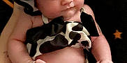Sariah is registered to the contest to win money with this photo: baby, infant, child, cow_print, hat, bonnet, clothing, black_and_white, pattern, cute, holding_hand, skin, person, newborn, portrait, indoors, background, fabric, relaxed, expression