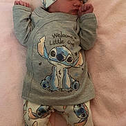 Sariah is registered to the contest to win money with this photo: baby, newborn, infant, child, cute, stitch, hat, clothing, pajamas, blanket, pink, lying_down, hand, face, sleepy, soft, adorable, patterned_clothes, indoors, cozy
