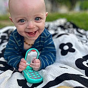 Camdyn joined the competition — help win amazing prizes! baby, babylaughing, blanket, clothing, electronics, face, footwear, grass, happy, head, laughing, mobilephone, outdoors, person, phone, photography, plant, portrait, sitting, smile