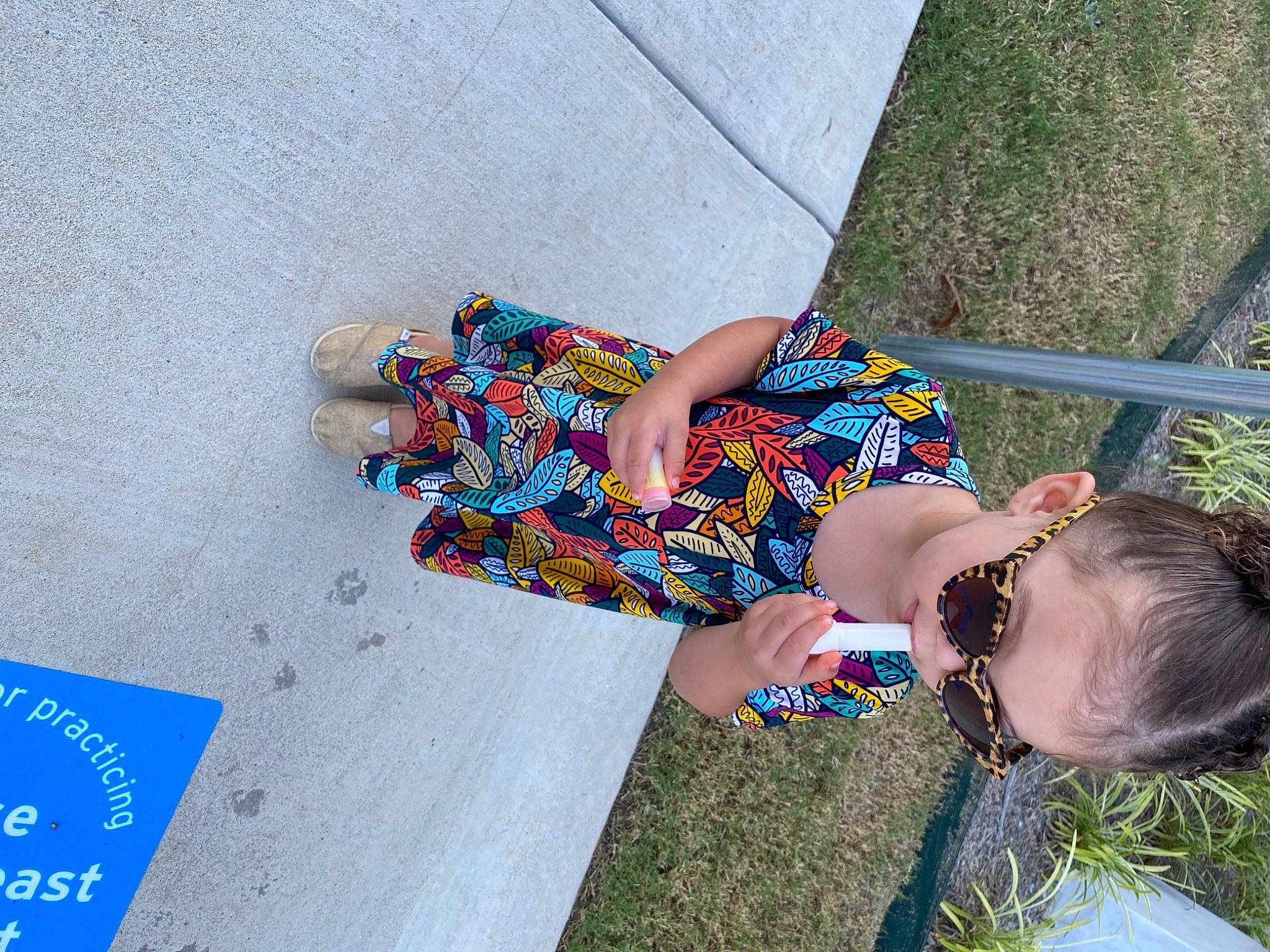 Kyrah is registered to the contest to win money with this photo: child, concrete, electric_blue, eyewear, fashion_accessory, fun, grass, happy, human_leg, leisure, logo, pattern, people_in_nature, person, plant, sitting, street_fashion, textile, thigh, toddler