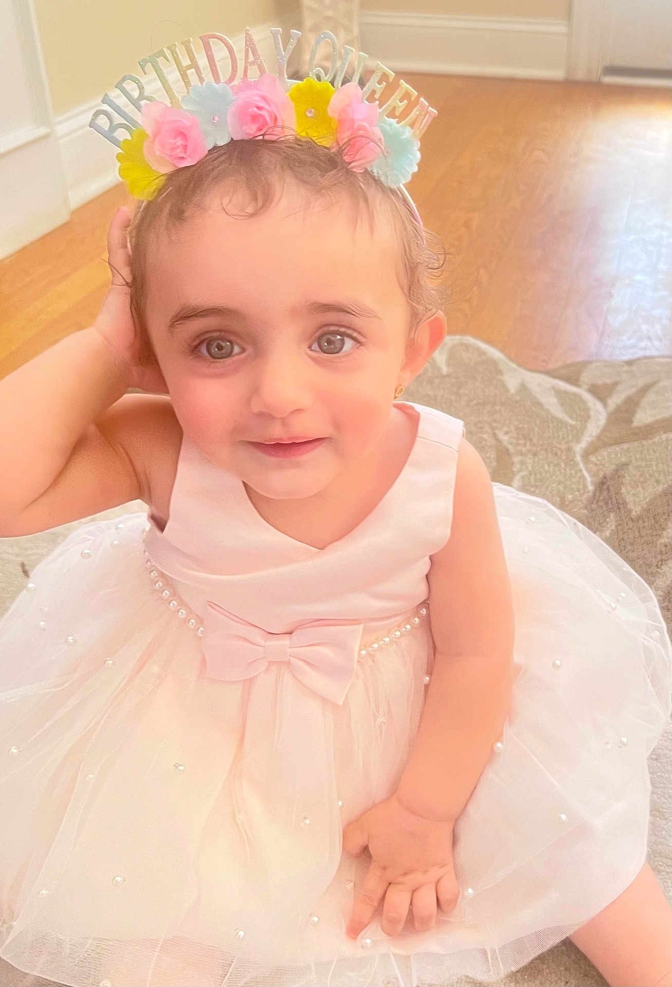 Engy is registered to the contest to win money with this photo: toddler, child, birthday, crown, flower_crown, dress, pink_dress, pearl, bow, indoor, floor, rug, cute, smile, portrait, baby, person, celebration, happy, young_child