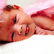 Gracelyn joined the competition — help win amazing prizes! adorable, baby, baby_clothing, child, closeup, cozy, cute, face, feathers, happy, headband, infant, lying_down, newborn, pink, portrait, skin, smile, soft, tongue