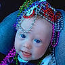 baby, child, blue_eyes, beads, colorful, mardi_gras, car_seat, smiling, face, closeup, infant, cute, playful, necklace, happy, portrait, clothing, seatbelt, headwear, accessories