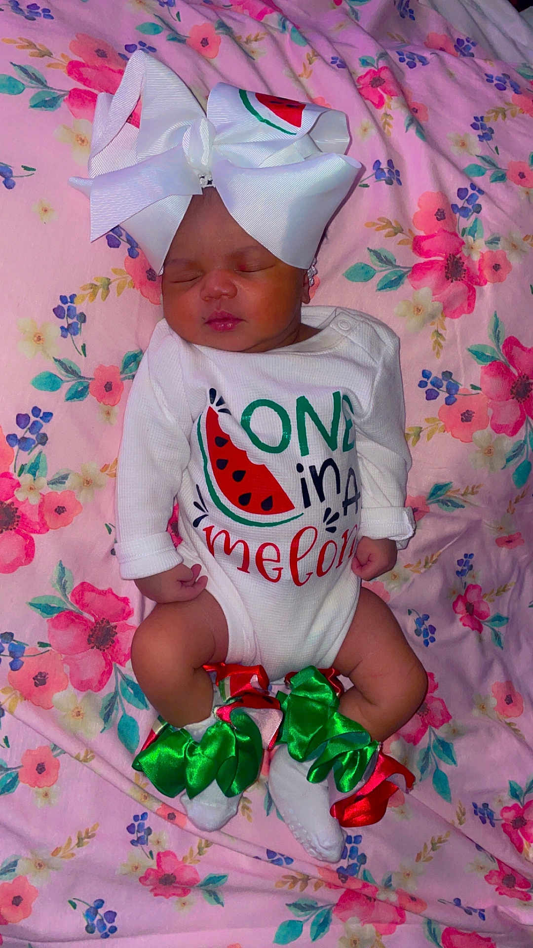 Cynturi is registered to the contest to win money with this photo: baby, sleeping, onesie, bow, ribbons, watermelon, floral_blanket, infant, cute, peaceful, clothing, feet, headwear, pattern, fabric, child, portrait, soft, resting, adorable