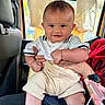 Victor joined the competition — help win amazing prizes! baby, infant, smile, child, car_seat, clothing, shorts, polo_shirt, hand, watch, car_interior, headrest, seat, person, cute, happy, skin, face, eyes, legs