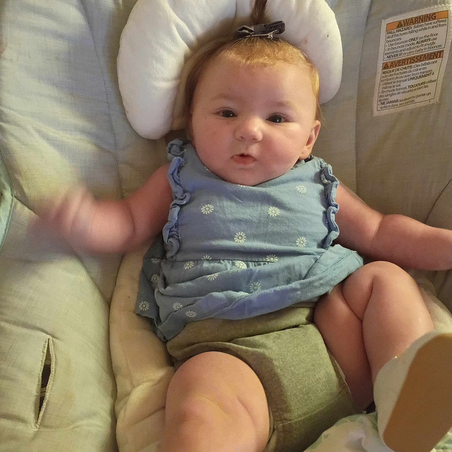 Ava joined the competition — help win amazing prizes! baby, child, infant, blue_top, green_shorts, baby_seat, cushion, pony_tail, bow, face, legs, arms, skin, indoor, expression, clothing, comfort, person, cute, portrait