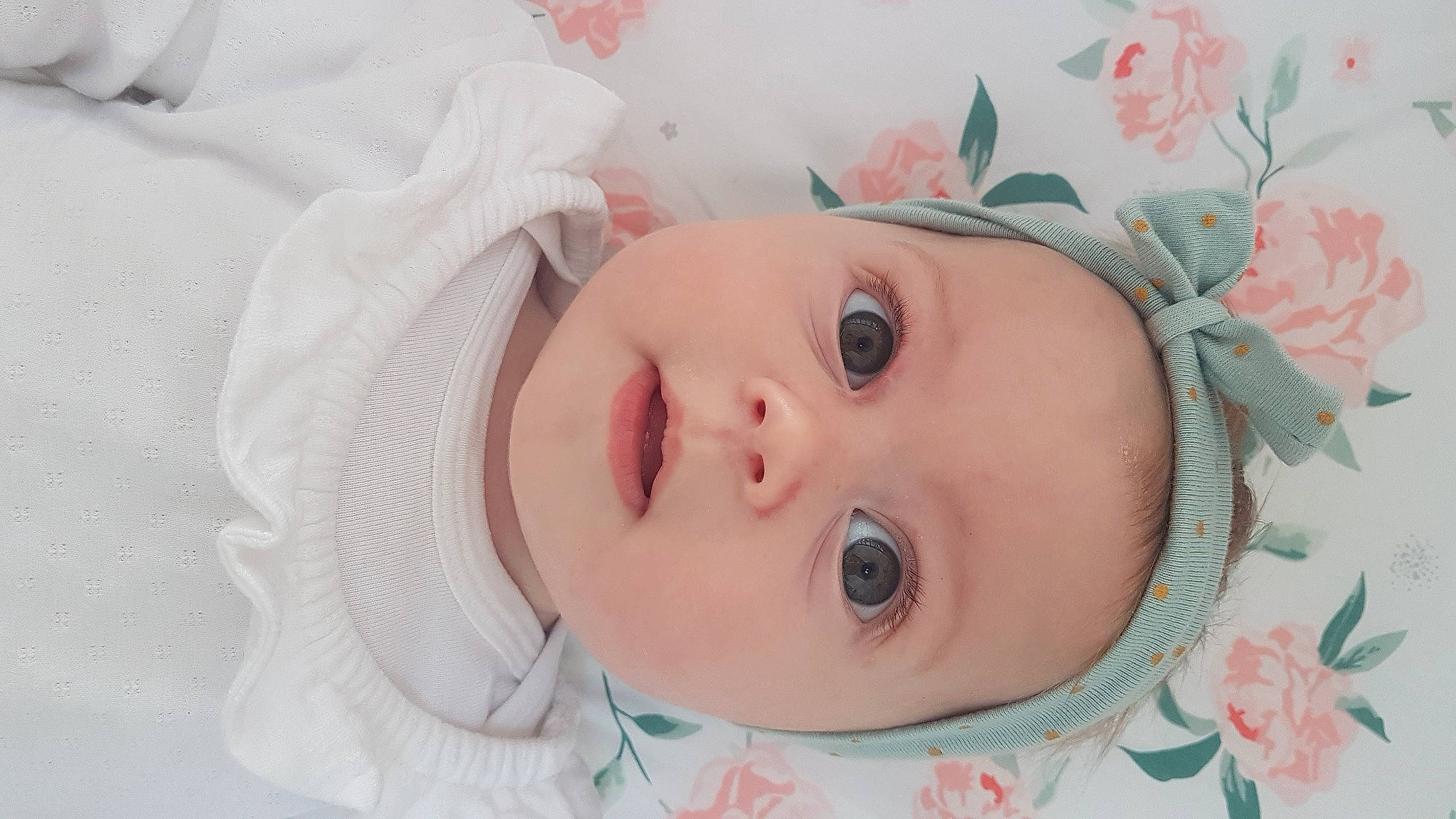 Ambre participe au concours pour gagner de l'argent avec cette photo : baby, baby_toddler_clothing, brown_hair, cheek, eyebrow, eyelash, fashion_accessory, hair_accessory, happy, headgear, headwear, iris, linens, lip, neck, nose, peach, person, pink, skin