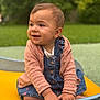 baby, child, smiling, denim_overalls, pink_sweater, outdoor, greenery, playground, boat, hands, face, happy, cute, infant, portrait, sitting, nature, daylight, clothing, closeup