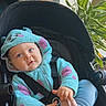 baby, child, stroller, hoodie, blue_clothing, purple_spots, indoor, plant, window, seatbelt, cute, infant, holding_foot, cozy, smiling, portrait, face, person, casual_wear, soft_light
