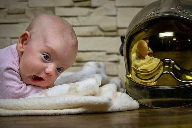 Yliana a rejoint le concours — aidez-le/la à gagner de superbes lots ! baby, baby_toddler_clothing, comfort, drinkware, fashion_accessory, flooring, glass, goggles, happy, helmet, linens, motorcycle_helmet, person, personal_protective_equipment, room, serveware, service, sitting, sports_gear, toddler