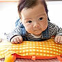 Alfred is registered to the contest to win money with this photo: baby, infant, child, face, hands, pillow, striped_clothing, denim_overalls, curious, indoor, soft_light, closeup, portrait, cute, skin, hair, expression, floor, blanket, playtime