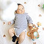 Alfred is registered to the contest to win money with this photo: baby, infant, striped_clothing, black_socks, plush_toy, teddy_bear, quilted_blanket, teddy_bear_pattern, lying_down, indoors, soft_toy, child, cute, adorable, playtime, white_background, infant_clothing, baby_boy, soft_lighting, hand_holding_toy
