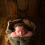Palmer is registered to the contest to win money with this photo: baby, newborn, sleeping, wooden_bucket, green_blanket, headband, infant, soft_texture, cozy, rustic, wood_floor, rope, portrait, peaceful, cute, child, closeup, indoors, resting, adorable