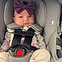 baby, child, car_seat, purple_bow, headband, floral_clothing, safety_harness, infant, cute, foot, indoors, seat, straps, padded, expression, person, toddler, comfort, young_child, portrait