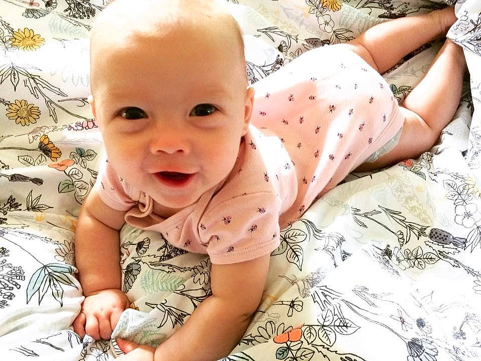 Bridget is registered to the contest to win money with this photo: baby, baby_toddler_clothing, beauty, cheek, child, design, hand, happy, head, human, leg, mouth, pattern, person, pink, product, sitting, skin, sleeve, smile