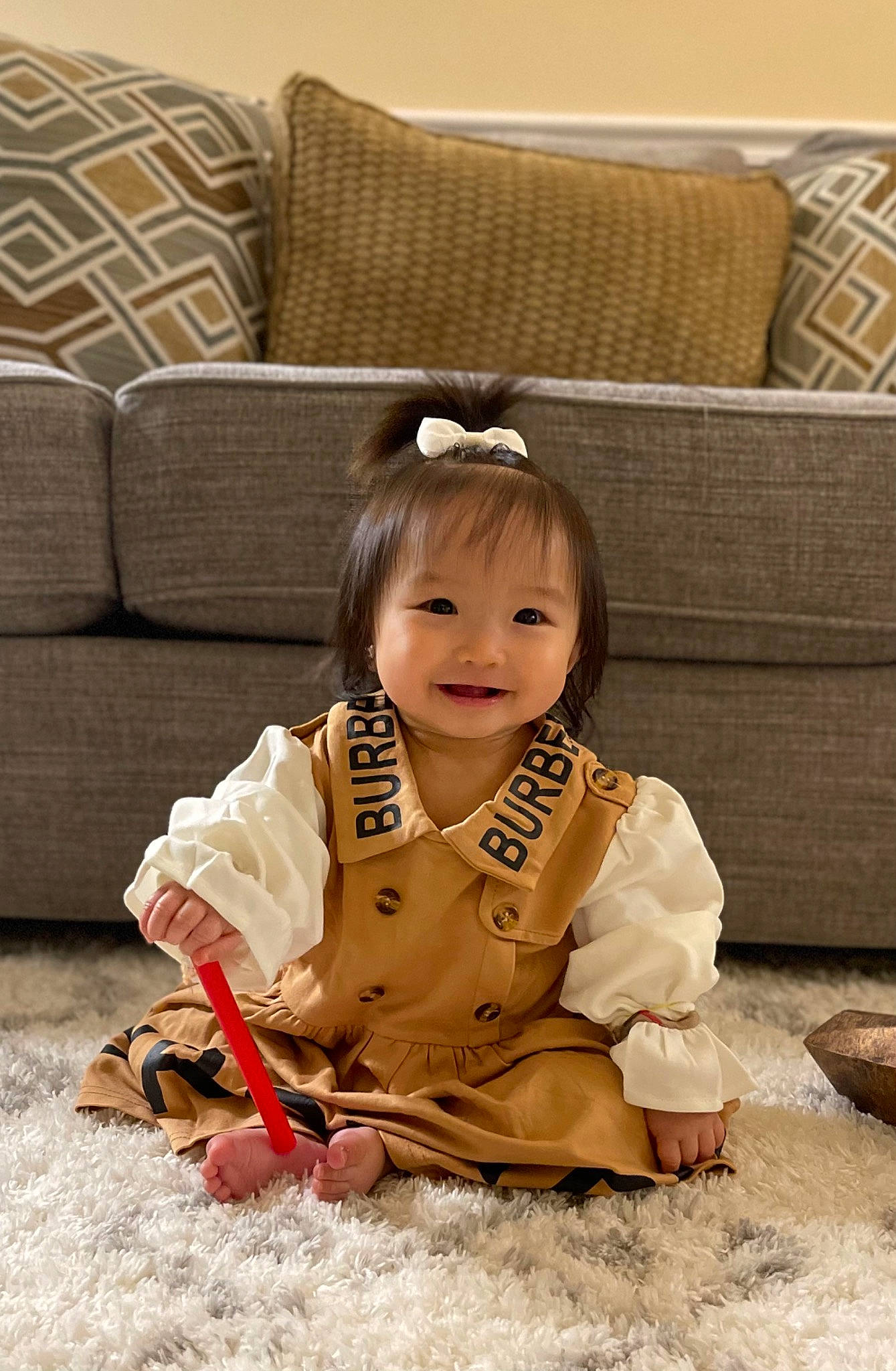 Chelsea is registered to the contest to win money with this photo: baby, baby_toddler_clothing, cheek, child, comfort, couch, eye, face, flooring, fun, happy, head, joy, living_room, person, portrait_photography, room, sitting, smile, toddler