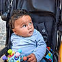 Idriss participe au concours pour gagner de l'argent avec cette photo : baby, child, stroller, toy, colorful_toy, drool, blue_shirt, jeans, curious, sitting, outdoor, face, hands, playful, infant, cute, expression, casual_clothing, portrait, young_child