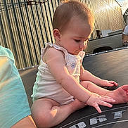 Paisley joined the competition — help win amazing prizes! arm, baby, background, basketball_hoop, building, casual_clothing, child, curious, daylight, earring, head, metal_building, outdoor, person, sitting, skin, summer, sunlight, toes, trampoline