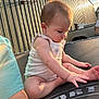 baby, child, trampoline, outdoor, sunlight, building, metal_building, basketball_hoop, curious, sitting, toes, casual_clothing, summer, daylight, person, skin, arm, head, earring, background