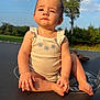 baby, child, trampoline, outdoor, sunlight, nature, grass, tree, cloud, sky, greenery, summer, casual_clothing, sitting, portrait, infant, cute, serious, barefoot, daytime