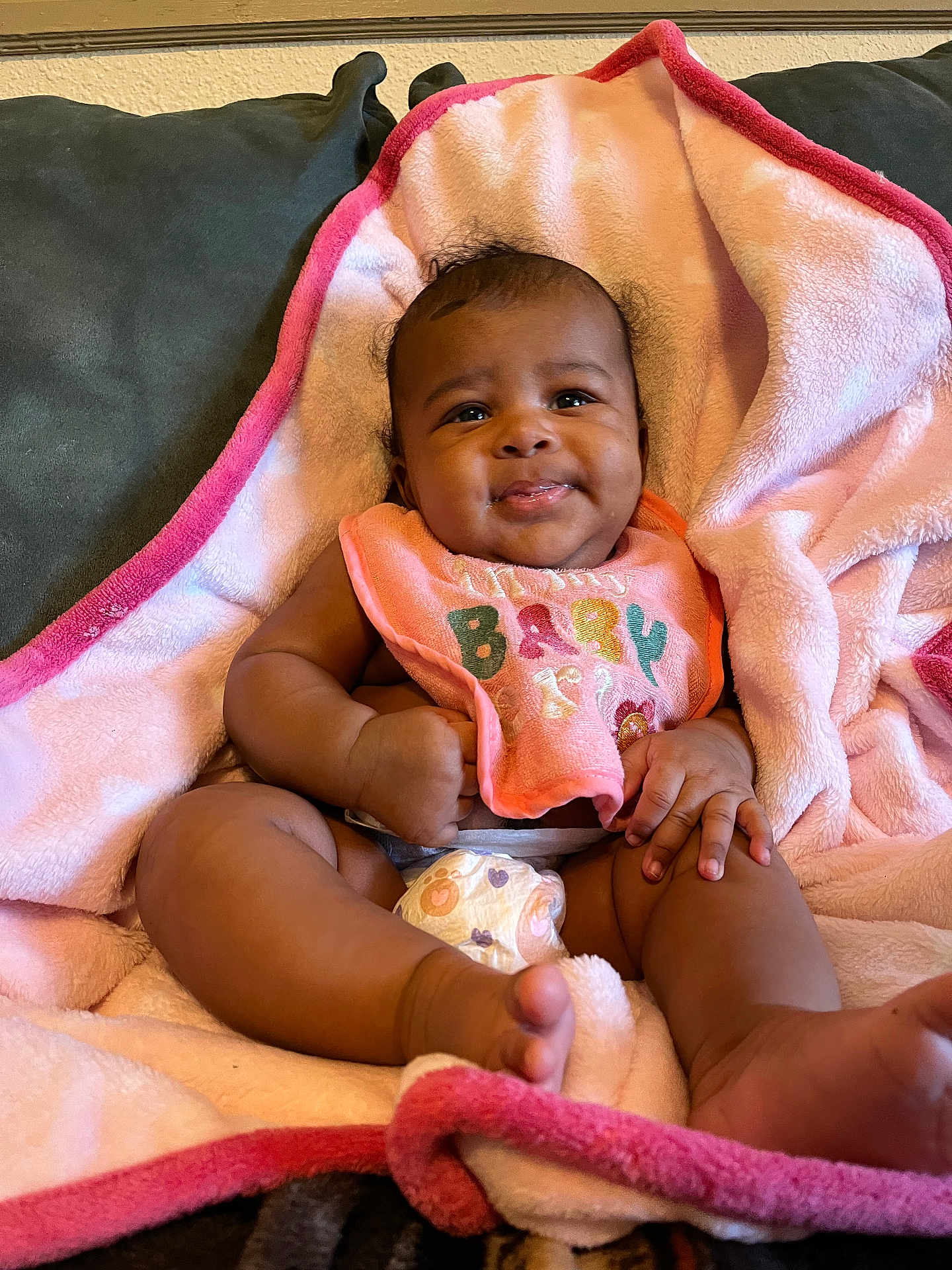 Samyra joined the competition — help win amazing prizes! baby, infant, smiling, blanket, pink, bib, diaper, couch, happy, cute, child, skin, hand, foot, face, expression, indoors, soft, relaxed, comfort