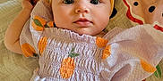 Nylah joined the competition — help win amazing prizes! baby, blanket, child, colorful, cute, dress, face, headband, indoors, infant, lying_down, orange_fruit, pattern, portrait, quilt, skin, small_hand, soft_texture, yellow, young
