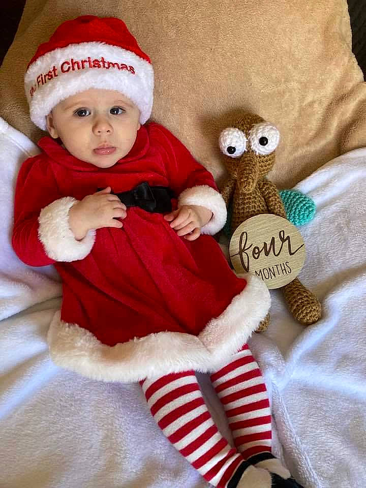 Annie joined the competition — help win amazing prizes! baby, baby_toddler_clothing, cap, christmas, christmas_decoration, christmas_eve, christmas_ornament, comfort, costume_hat, doll, event, headgear, headwear, holiday, lap, ornament, person, santa_claus, sleeve, sock