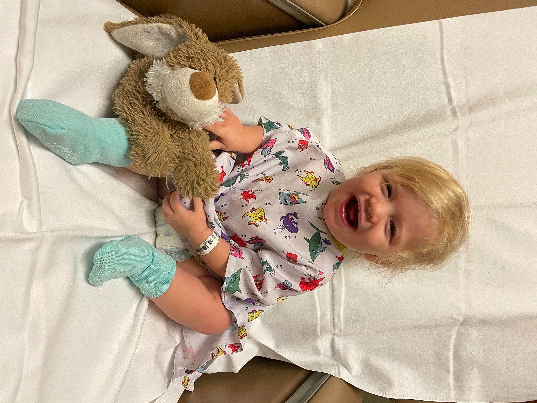 Kennedi is registered to the contest to win money with this photo: bed, bedding, child, comfort, couch, gesture, happy, joint, linens, pattern, person, plush, room, skin, sleeve, smile, stuffed_toy, t_shirt, textile, toddler
