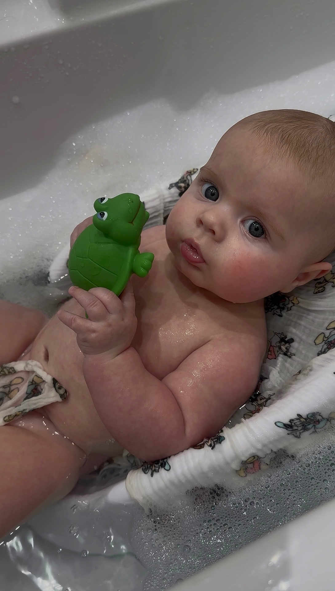 Hudson joined the competition — help win amazing prizes! baby, child, bath, bathtub, water, foam, toy, turtle, skin, hand, face, eyes, expression, cute, wet, infant, sitting, closeup, bathroom, playtime