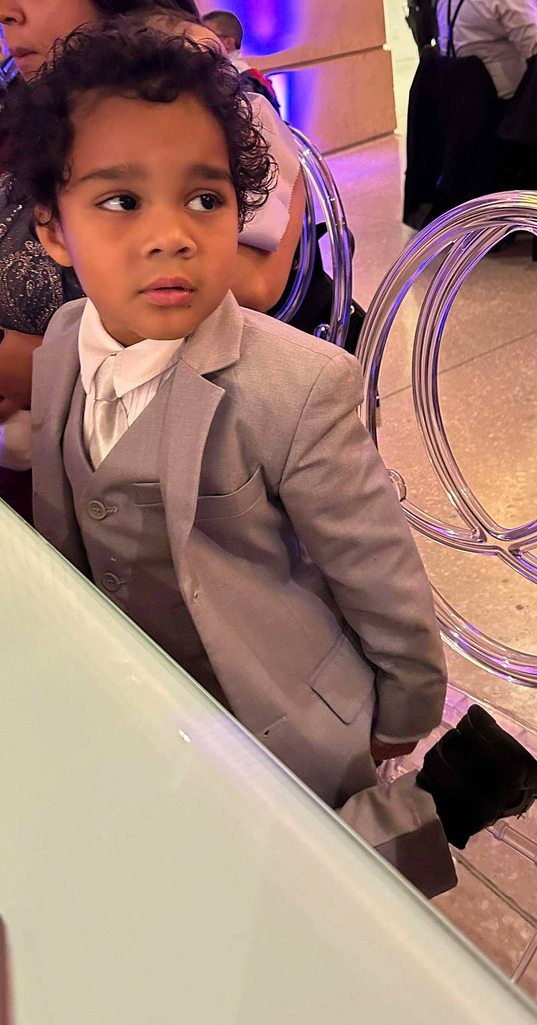 Leon is registered to the contest to win money with this photo: audio_equipment, blazer, child, dress_shirt, event, fashion_accessory, flash_photography, formal_wear, fun, hairstyle, happy, headphones, jewellery, microphone, official, person, sitting, suit, tie, uniform