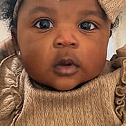 Calia joined the competition — help win amazing prizes! baby, child, face, headband, bow, curly_hair, clothing, portrait, closeup, cute, expression, indoor, person, young_child, fashion, texture, skin, eyes, infant, adorable