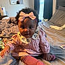 baby, child, pink_dress, headband, socks, bed, blanket, curly_hair, indoor, portrait, cute, smiling, person, infant, cozy, soft_lighting, furniture, window, decor, playful